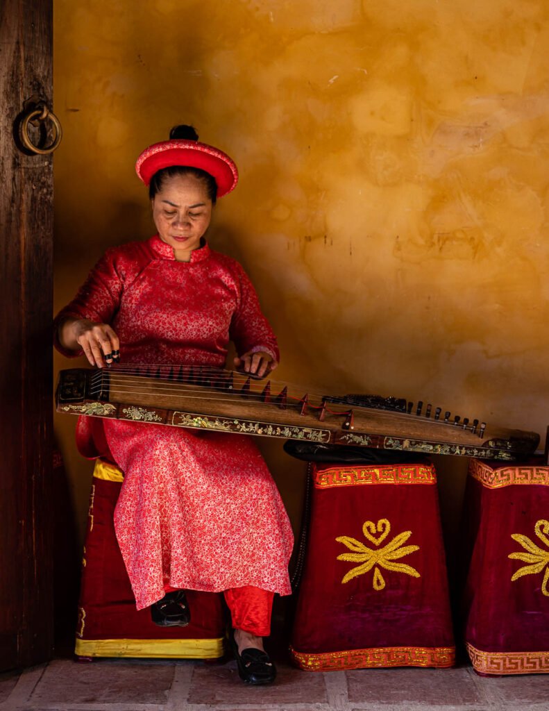 vietnamese woman in traditional vietnamese red clothes playing musical instrument dan tranh